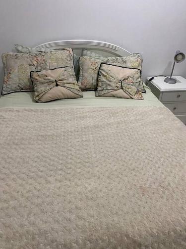 - un grand lit avec des oreillers dans l'établissement Alojamiento en Apartamento en Ricaurte, à Ricaurte