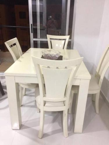 a white dining room table with white chairs at Alojamiento en Apartamento en Ricaurte in Ricaurte