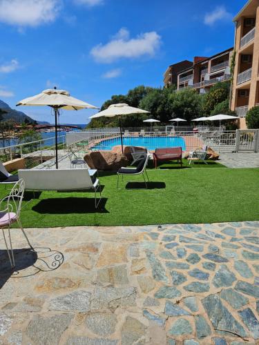 a group of chairs and umbrellas next to a pool at Le Marina in Porto Ota