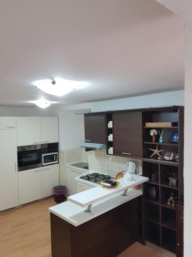 uma cozinha com armários brancos e um balcão branco em Karla Babić em Senj