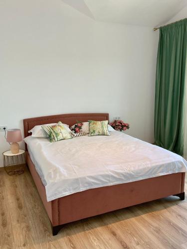 a bed in a bedroom with a green curtain at Residence Odaile #9 in Otopeni
