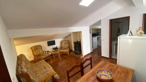 a living room with a table and chairs and a kitchen at Apartamento Miradouro in Carrapateira