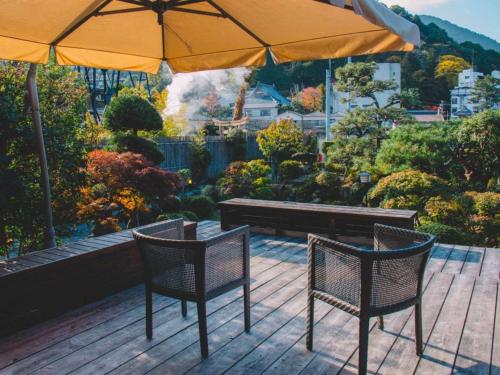two chairs and a table and an umbrella on a deck at WASEIDOU ZEN - Vacation STAY 17260v in Kobe