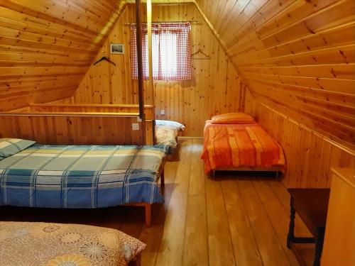 a bedroom with two beds in a wooden cabin at Cottage Lepena in Soča