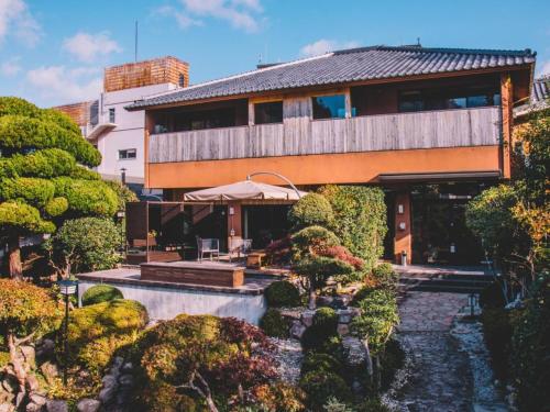 una casa con un estanque frente a un jardín en WASEIDOU ZEN - Vacation STAY 19515v en Kobe