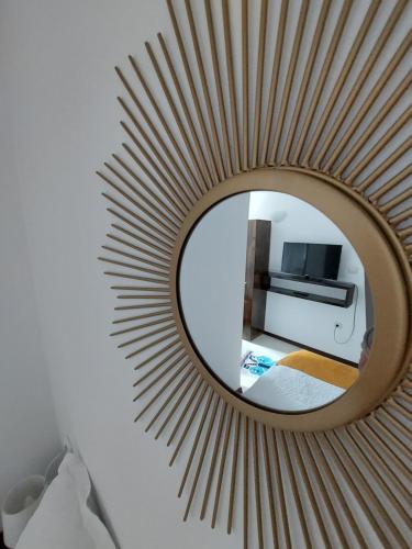 a mirror on a wall with a bed and a room at Casa Nico Nelu Duplex in Arieşeni