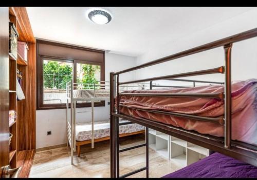 Un dormitorio con dos literas y una ventana. en Casa rustica con piscina y jardin, en Pineda de Mar