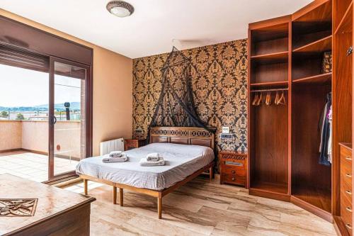 Un dormitorio con una cama y una ventana grande. en Casa rustica con piscina y jardin, en Pineda de Mar