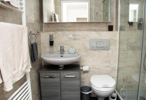 a bathroom with a sink and a toilet and a mirror at Apartment am Kurpark in Bad Segeberg