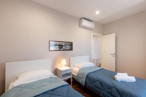 een slaapkamer met 2 bedden en een tafel met een lamp bij Casa mia a Nervi in Genua