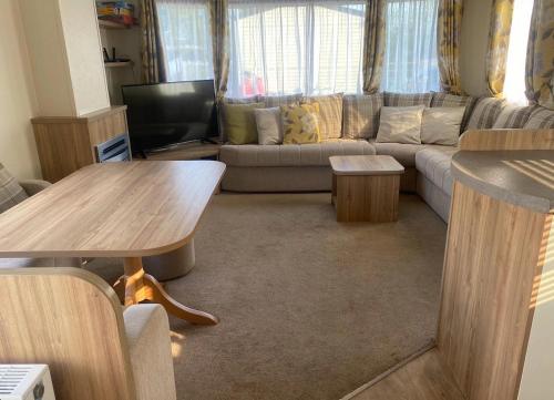 uma sala de estar com um sofá e uma mesa em Beach Caravan Holiday Home em Mablethorpe