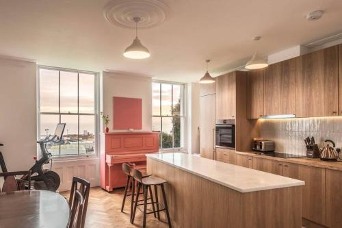 a kitchen with wooden cabinets and a table and a stove at Jane's View - Luxury apartment with breathtaking views in Kent