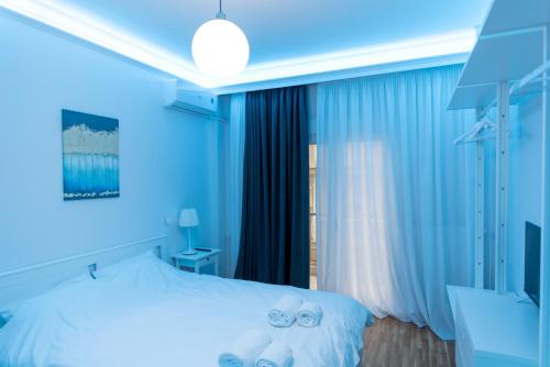 Un dormitorio azul con una cama con toallas. en Athina Pantheon Mitropoleos en Tesalónica