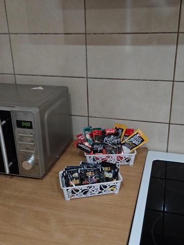 three packs of candy next to a microwave at Duca apartmani in Šabac
