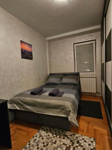 ein Schlafzimmer mit einem großen Bett in einem Zimmer in der Unterkunft Duca apartmani in Šabac