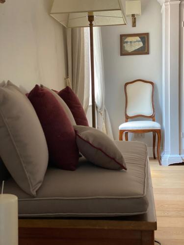 a couch with pillows on it with a chair at Burlamacchi Villas in Bagni di Lucca