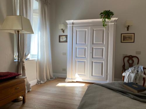 a bedroom with a door and a bed and a lamp at Burlamacchi Villas in Bagni di Lucca