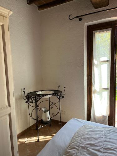 a bedroom with a table and a bed and a window at Agriturismo Monte Gusciani in Massa Marittima