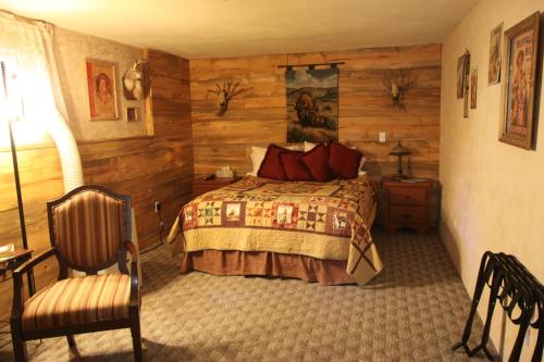 1 dormitorio con 1 cama y 1 silla en Whitebird Summit BNB, en Whipsaw Saddle