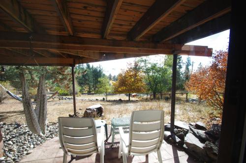 a patio with a table and chairs under a roof at Whitebird Summit BNB in Whipsaw Saddle