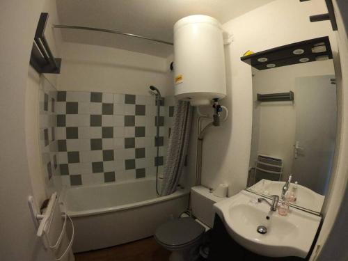 une salle de bain avec un lavabo, des toilettes et une baignoire dans l'établissement Appartement avec piscine et garage, au Grau-du-Roi