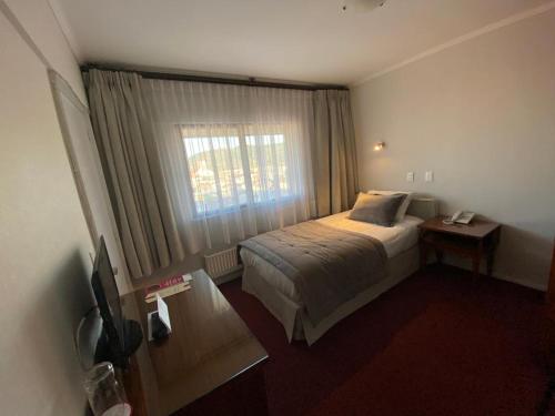 a hotel room with a bed and a window at Hotel Nicolás Temuco in Temuco