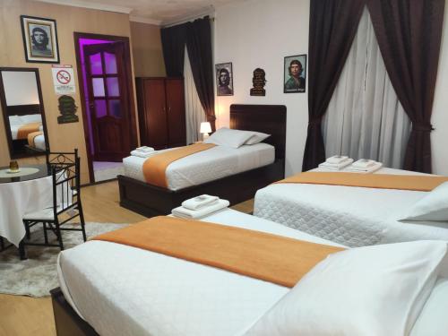a hotel room with two beds and a table at Hotel el Che No apto para corruptos in Azogues