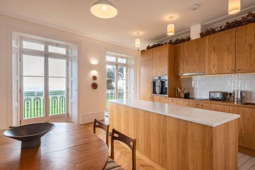uma cozinha com armários de madeira, uma mesa e um balcão em Royal Channel Retreat - Stunning apartment - glorious views em Kent