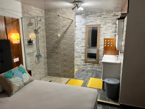 a bathroom with a shower and a bed and a sink at Miki Miki House in Fare