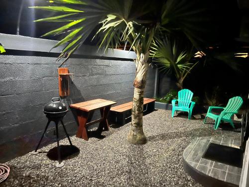 a patio with a table and chairs and a palm tree at Miki Miki House in Fare