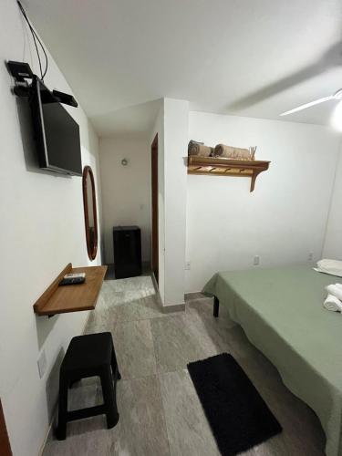 a room with a bed and a table and a chair at Pousada Luz da Lua in Búzios