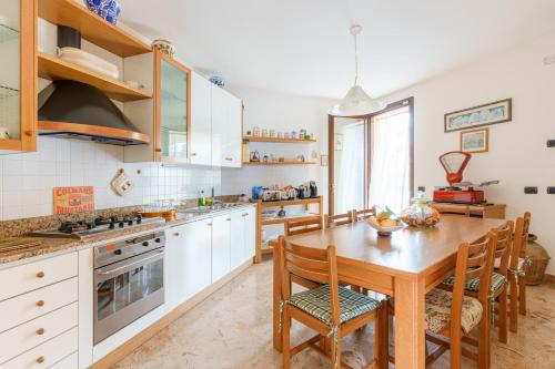 a kitchen with a wooden table and wooden chairs at Le Rose - Suites e Breakfast a 5 min dal mare e Misano World Circuit in Misano Adriatico