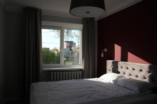 a bedroom with a bed and a large window at Luxuria Modern Apartments - Self Check-in in Šiauliai