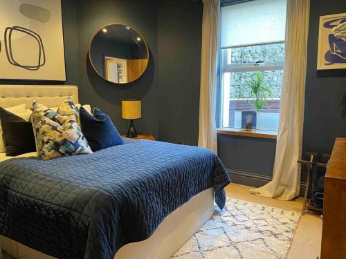 Schlafzimmer mit einem Bett mit einem Spiegel und einem Fenster in der Unterkunft Stunning apartment by The Leas, West End in Kent