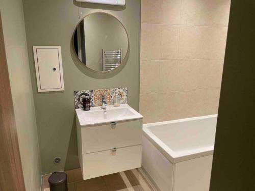 a bathroom with a sink and a mirror and a tub at Stunning apartment by The Leas, West End in Kent