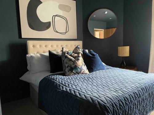 a bedroom with a bed with a blue comforter and a mirror at Stunning apartment by The Leas, West End in Kent