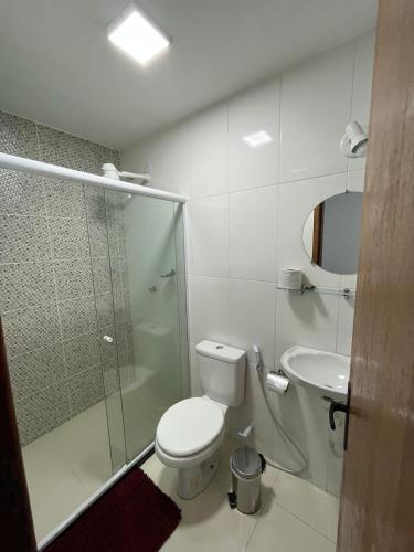 a bathroom with a toilet and a shower and a sink at Pousada Luz da Lua in Búzios