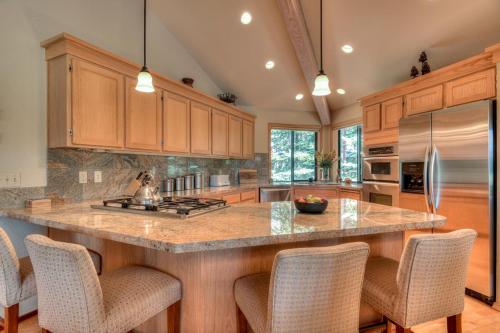 Una cocina con una gran isla con sillas de bar. en Pole House - Unit 1, en Sunriver