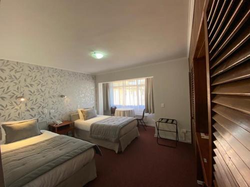 ein Hotelzimmer mit 2 Betten und einem Fenster in der Unterkunft Hotel Nicolás Temuco in Temuco