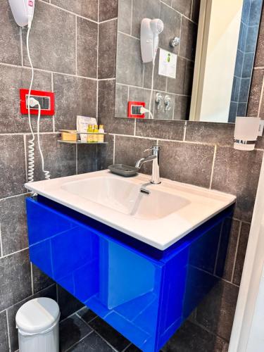 ein Badezimmer mit einem weißen Waschbecken und blauen Schränken in der Unterkunft Yacht Club Angioino in Neapel