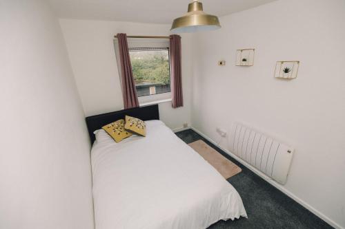 1 dormitorio con cama blanca y ventana en Luxe Spacious & Central 2Bed Luton Apartment - Free Parking - Free Wi-Fi - Near LTN Airport & L&D Hospital, en Luton