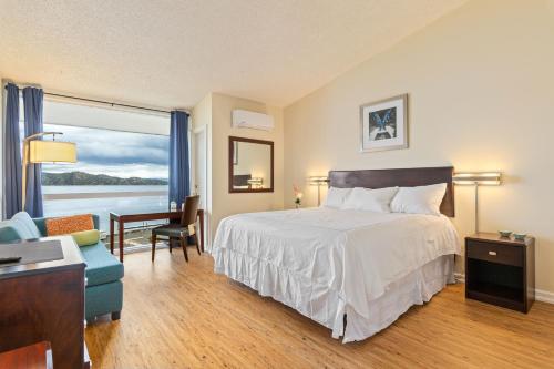 Schlafzimmer mit einem Bett, einem Schreibtisch und einem Fenster in der Unterkunft Konocti Harbor Resort in Kelseyville
