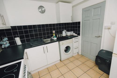 a small kitchen with a washer and dryer in it at Luxe Spacious & Central 2Bed Luton Apartment - Free Parking - Free Wi-Fi - Near LTN Airport & L&D Hospital in Luton