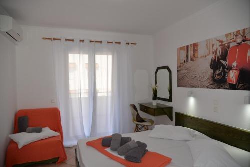 a bedroom with a bed and two chairs and a window at VILLA CARIATIS in Nea Kalikratia
