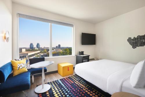 a hotel room with a bed and a large window at Aloft Atlanta Perimeter Center in Sandy Springs