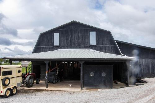a large barn with a tractor parked in front of it at Farmhouse of Blessings in Dundee