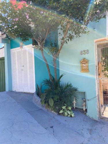 ein blaues Haus mit einem Baum davor in der Unterkunft Casa da Vila Pousada in Três Coroas