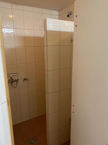 a bathroom with a shower with white tiles at Gasthuys de Peel in Ospel