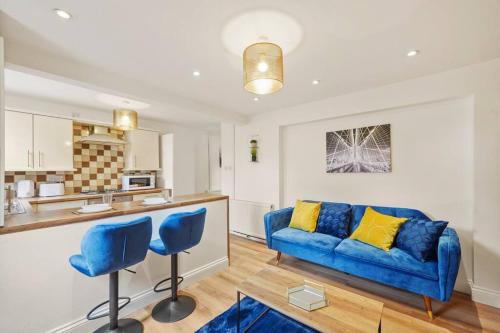 sala de estar con sofá azul y cocina en Sleeps 5 - Large Garden - Wifi en Kent