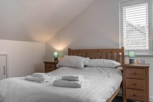 Seascape - Modern one bedroom, two storey annexe في Kent: غرفة نوم بسرير ابيض عليها مناشف